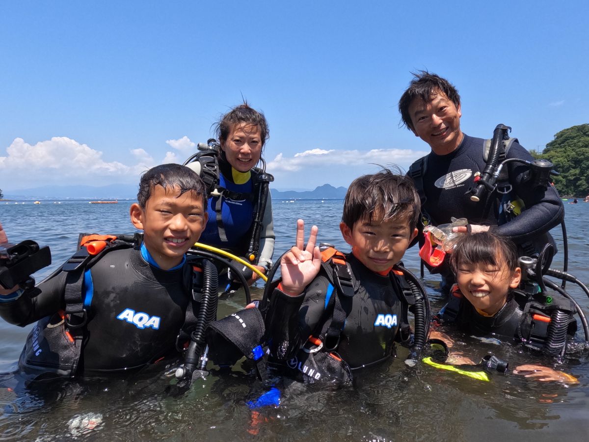 伊豆大瀬崎の青い海で体験ダイビングを楽しむ笑顔の親子（小学生の子供と親）の水中の様子